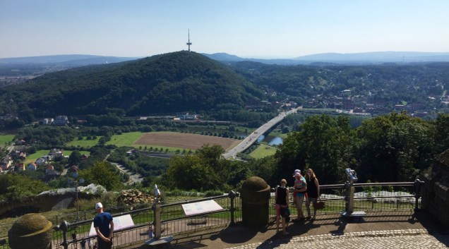 The Kaiser memorial at Porta Westfalica gives a great view of the surrounding hills and forests. At the bank of the river Weser, bottom, you can see the railway station built for the monument.